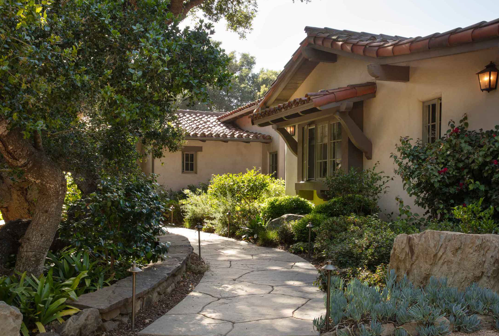 Mediterranean style courtyard with stone path and mature planting